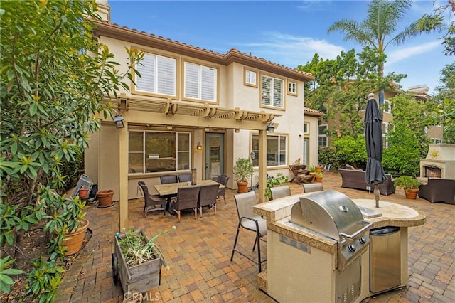 6 Heatherwood, Irvine, CA 92620 - view of patio / terrace featuring an outdoor kitchen, a warm lit fireplace, a grill, and outdoor dining area