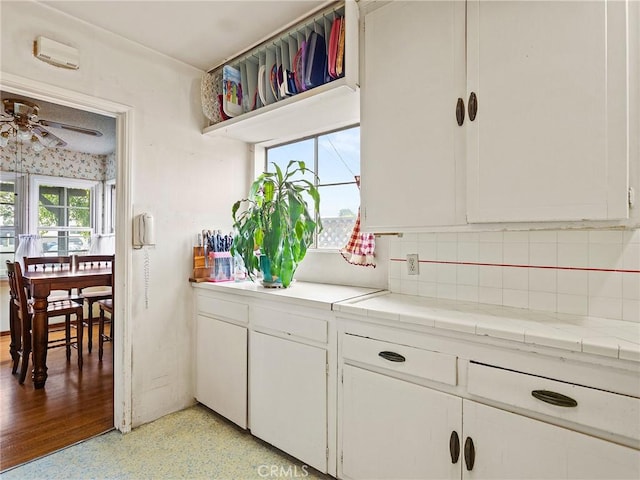 1234 N Ontario St, Burbank, CA 91505 - kitchen with ceiling fan, white cabinets, decorative backsplash, light countertops, and dark aggregate flooring