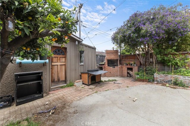 view of patio / terrace with an outdoor brick fireplace and a fenced backyard