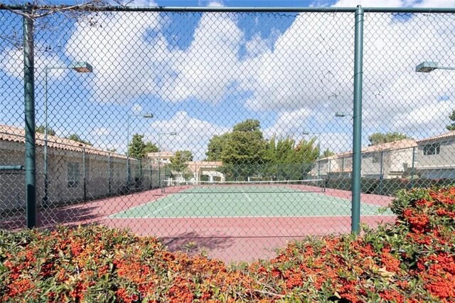 view of tennis court featuring fence