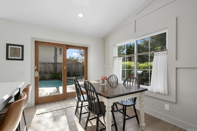 dining space with vaulted ceiling, light wood finished floors, recessed lighting, and baseboards
