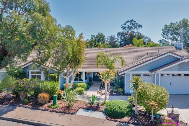 view of front of home with a tiled roof and an attached garage