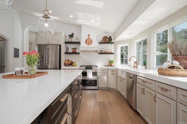 kitchen featuring appliances with stainless steel finishes, open shelves, light wood-style flooring, light countertops, and recessed lighting