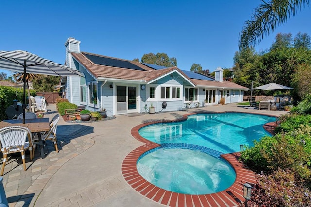 view of pool featuring a patio, outdoor dining space, a pool with connected hot tub, and fence