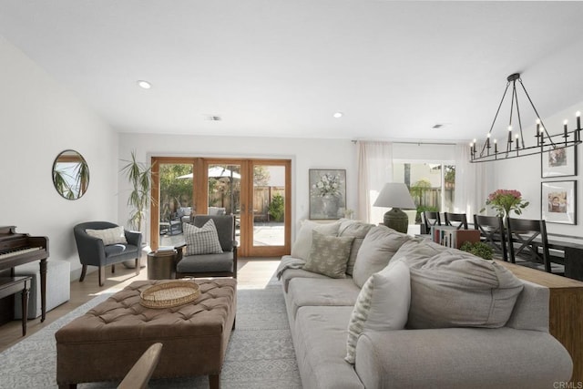 living room with a chandelier, light wood-type flooring, french doors, and recessed lighting