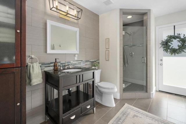 bathroom with tile patterned floors, toilet, a stall shower, and vanity