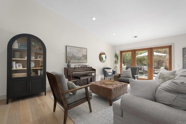 living room featuring light wood-style flooring, french doors, lofted ceiling, and recessed lighting