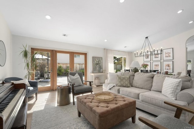 living room with french doors, arched walkways, recessed lighting, and a chandelier
