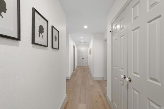 hallway featuring recessed lighting, light wood-style floors, and baseboards