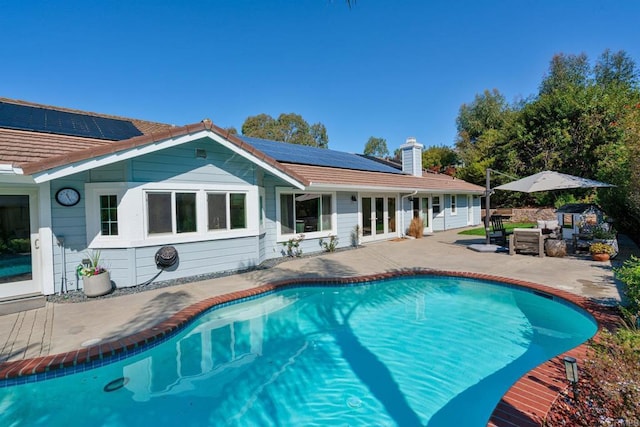 swimming pool with french doors and a patio area