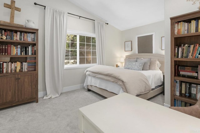 bedroom with light carpet, lofted ceiling, and baseboards