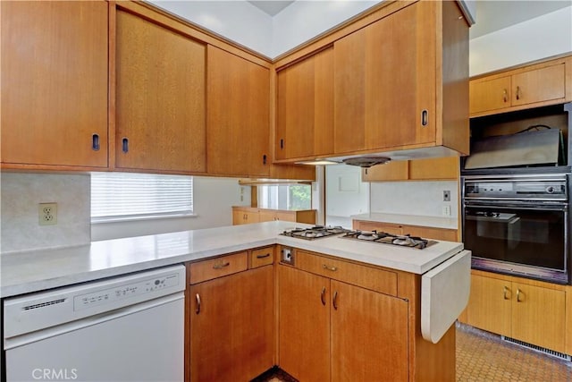 kitchen featuring white appliances, light countertops, and brown cabinetry