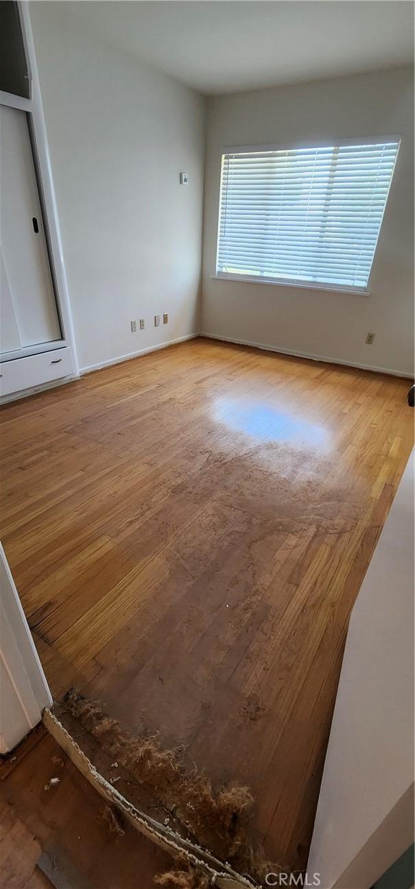 unfurnished room with wood finished floors and baseboards