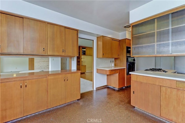 kitchen featuring light countertops, white gas stovetop, oven, and dark flooring