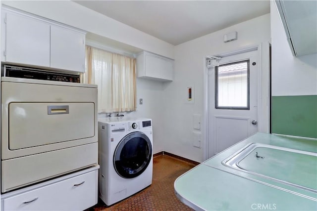 laundry area with separate washer and dryer, dark tile patterned flooring, and baseboards