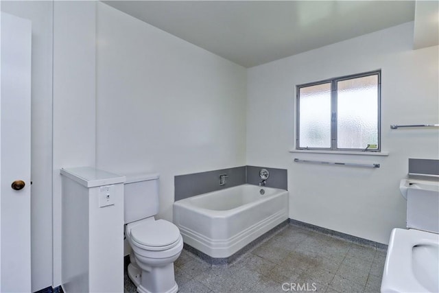 full bathroom with toilet, a bath, granite tiled floors, and baseboards