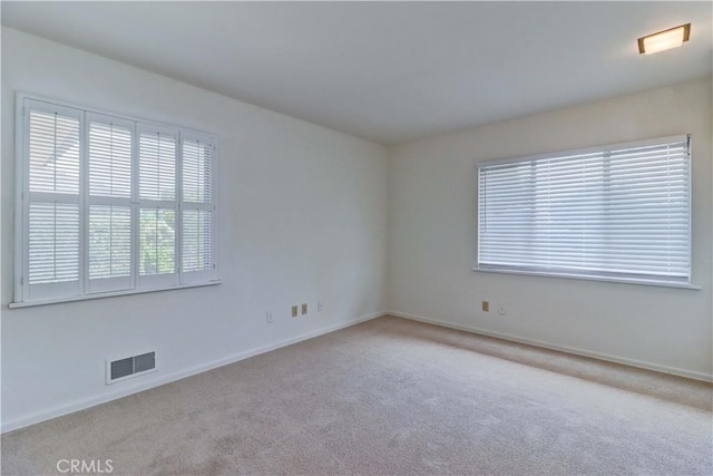 unfurnished room with carpet and baseboards