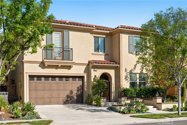 mediterranean / spanish house featuring a balcony, concrete driveway, a tiled roof, a garage, and stucco siding