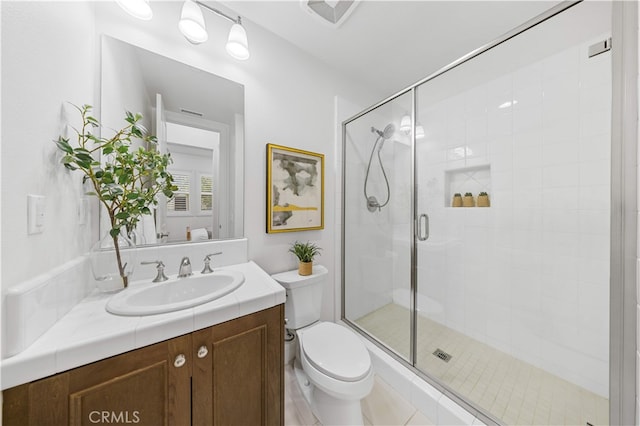 full bath featuring a stall shower, toilet, and vanity