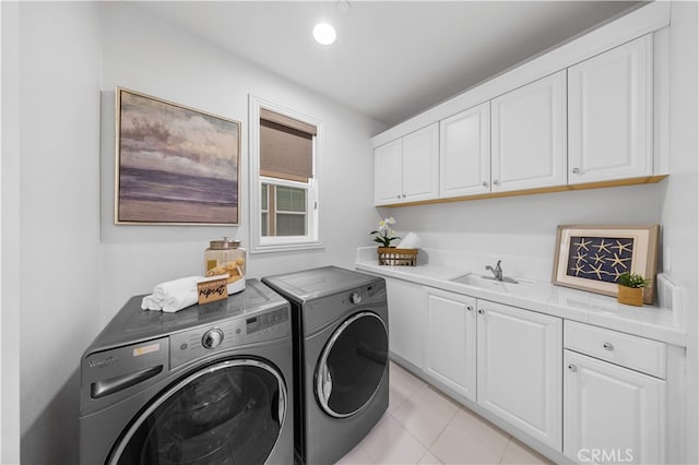 laundry room featuring separate washer and dryer, cabinet space, and light tile patterned floors