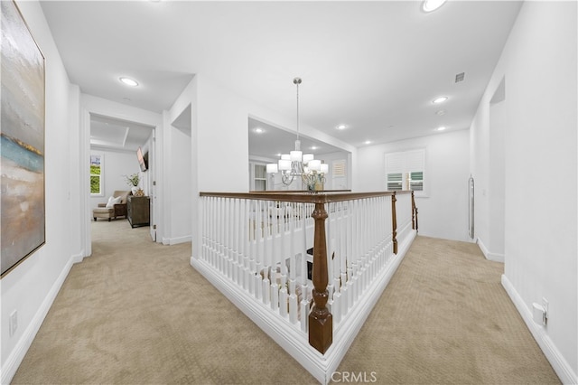 hall featuring carpet, a chandelier, recessed lighting, and baseboards