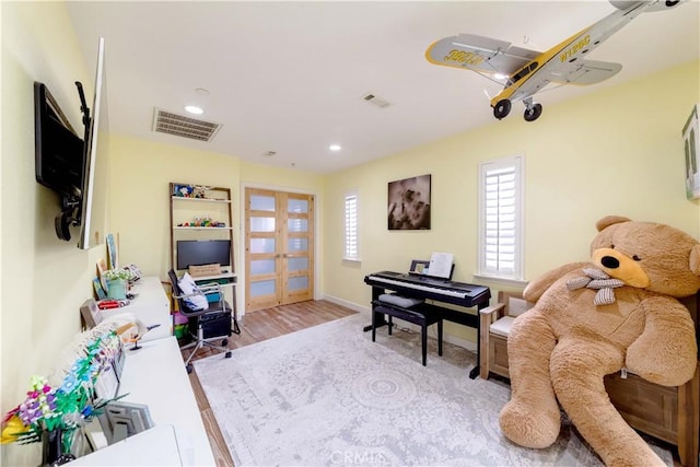 living area with french doors, wood finished floors, recessed lighting, and baseboards