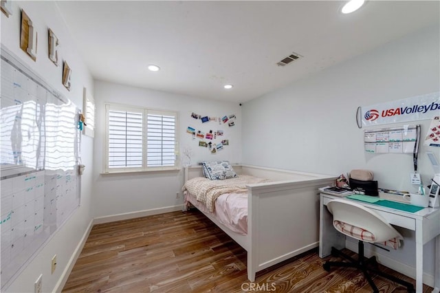bedroom with wood finished floors, recessed lighting, and baseboards