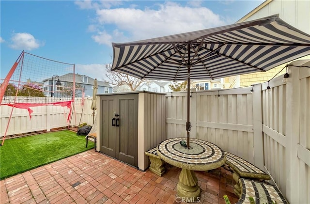 view of patio / terrace featuring a storage unit and an outbuilding