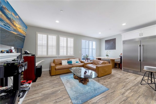 living room with light wood-style flooring, recessed lighting, and baseboards