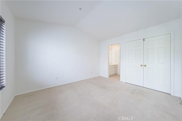 12671 Nicklaus Ln, Tustin, CA 92782 - unfurnished bedroom with lofted ceiling, light colored carpet, baseboards, a closet, and ensuite bathroom