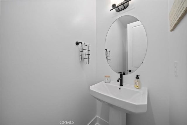 bathroom featuring a sink and baseboards