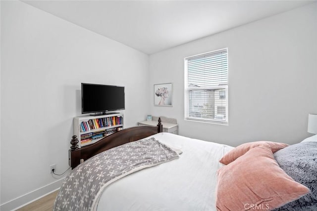 bedroom featuring wood finished floors and baseboards