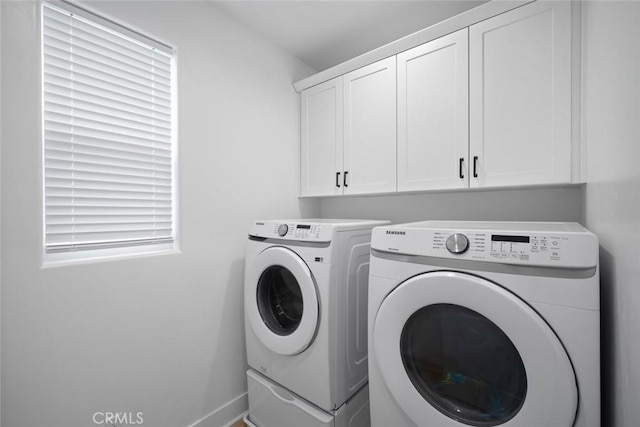 laundry room featuring washer and clothes dryer, cabinet space, and baseboards