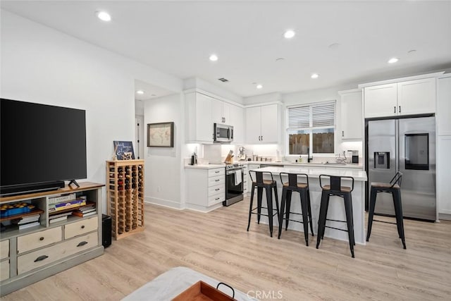 living room featuring light wood-type flooring, recessed lighting, and baseboards