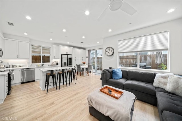living area featuring light wood-style floors, recessed lighting, and a ceiling fan