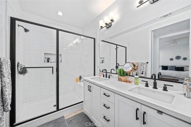 full bath featuring connected bathroom, a stall shower, and double vanity