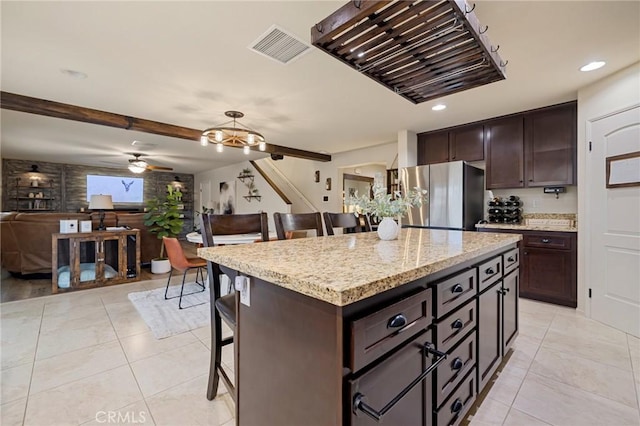 kitchen featuring freestanding refrigerator, a breakfast bar area, ceiling fan, open floor plan, and light tile patterned floors