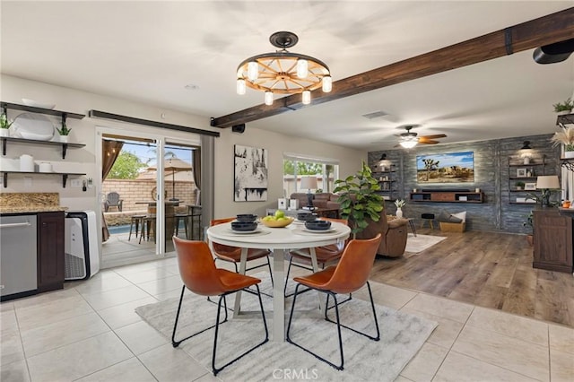 dining area with light tile patterned floors, beamed ceiling, ceiling fan, and a chandelier