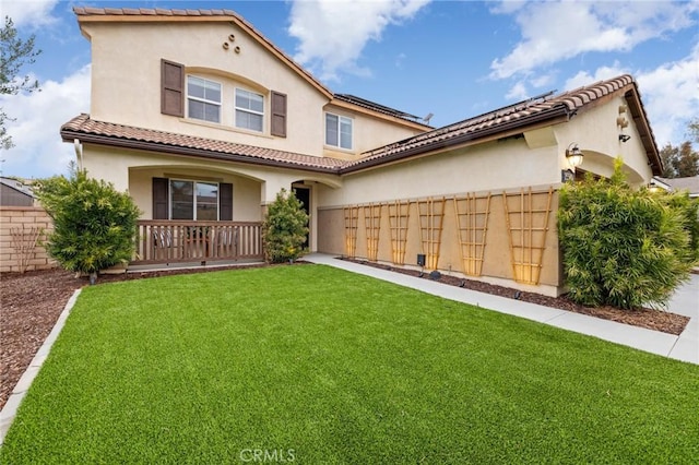 rear view of property featuring stucco siding, a tile roof, and covered porch