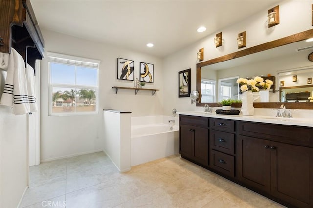 bathroom featuring plenty of natural light, double vanity, a garden tub, tile patterned floors, and recessed lighting