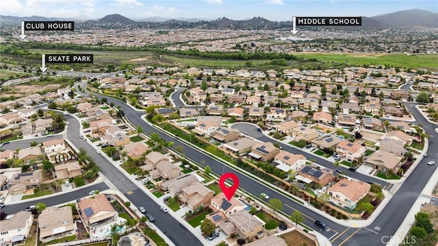 aerial overview of property's location featuring a mountainous background and nearby suburban area