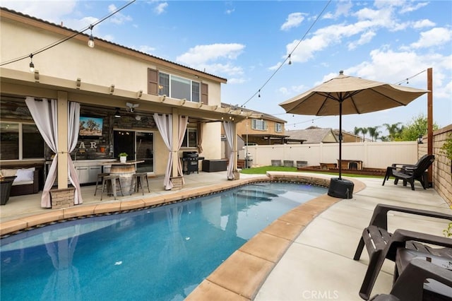 view of swimming pool with fence, a patio area, and a grill