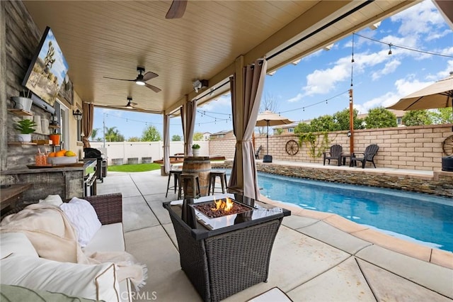 view of swimming pool featuring a fenced backyard, a patio, ceiling fan, and an outdoor living space with a fire pit