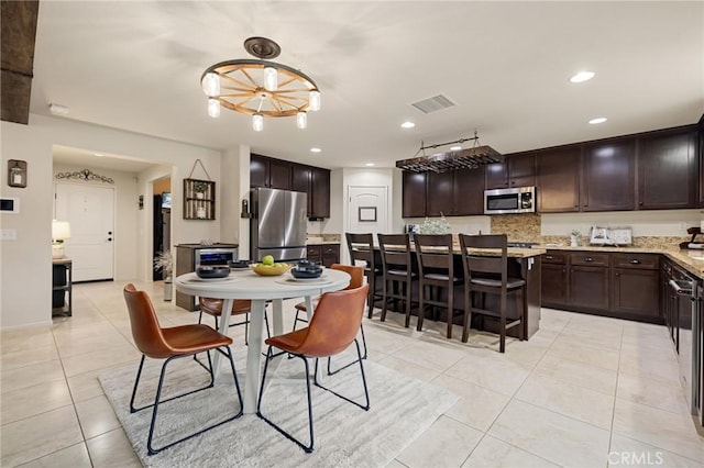 dining space with light tile patterned flooring and recessed lighting