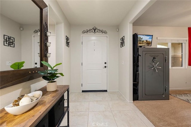 foyer entrance featuring baseboards and light tile patterned floors