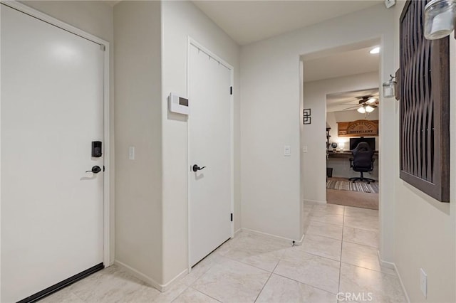 entrance foyer featuring baseboards, a ceiling fan, and light tile patterned floors