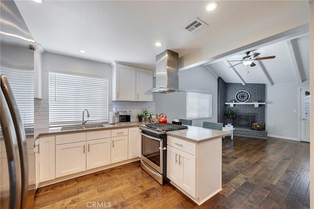812 N Fern St, Orange, CA 92867 - kitchen featuring stainless steel appliances, wall chimney exhaust hood, a peninsula, open floor plan, and hardwood / wood-style floors