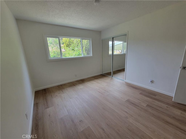 12406 Benson Ave, Chino, CA 91710 - unfurnished bedroom with wood finished floors, a textured ceiling, a closet, and baseboards