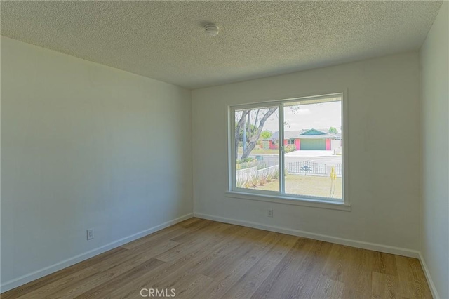 12406 Benson Ave, Chino, CA 91710 - spare room with light wood-style floors, a textured ceiling, baseboards, and a smoke detector
