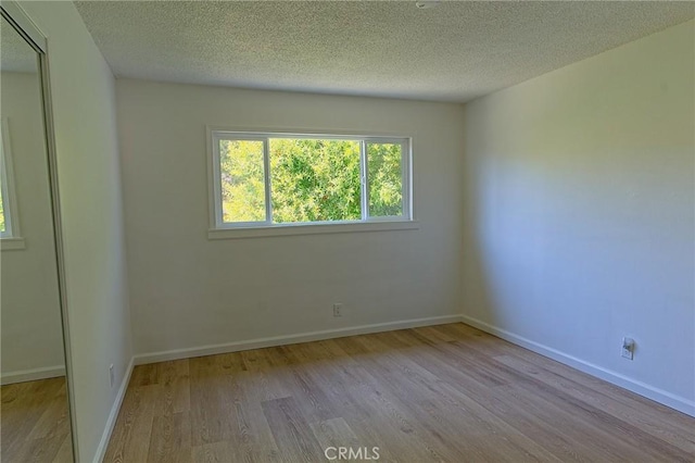 12406 Benson Ave, Chino, CA 91710 - empty room with wood finished floors, a textured ceiling, and baseboards